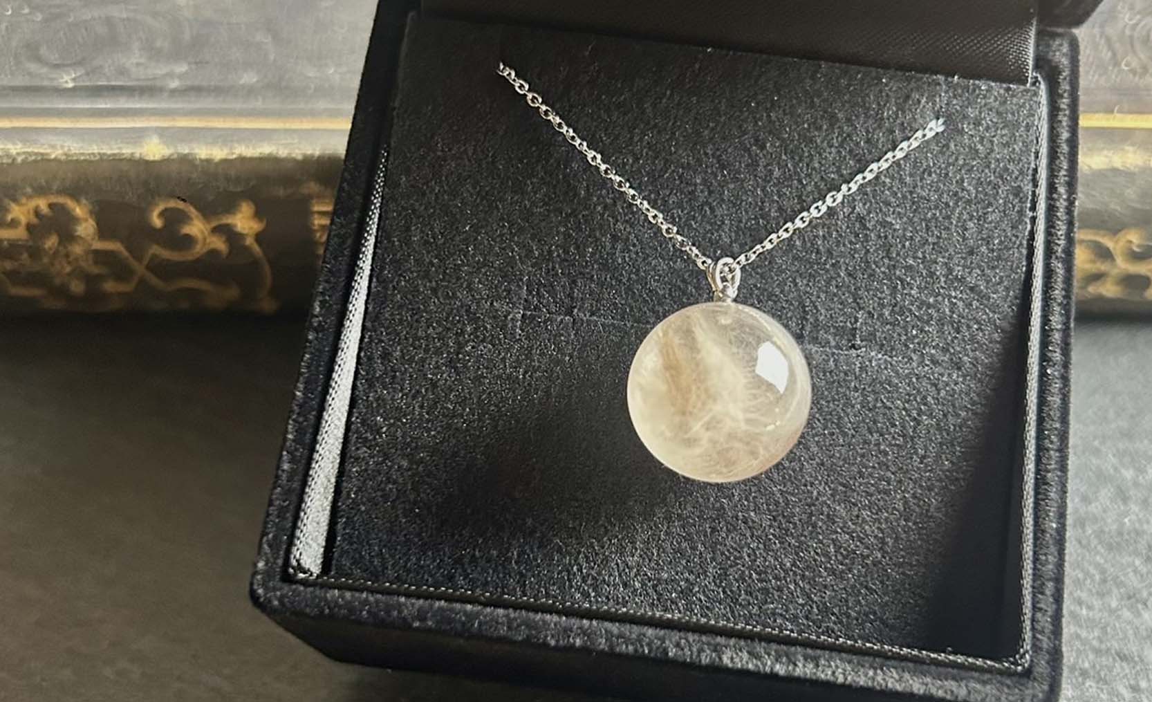 ハムスターの毛を封入した透明レジンの球体ネックレス。毛がふんわりと広がり美しく保存されたメモリアルアクセサリー